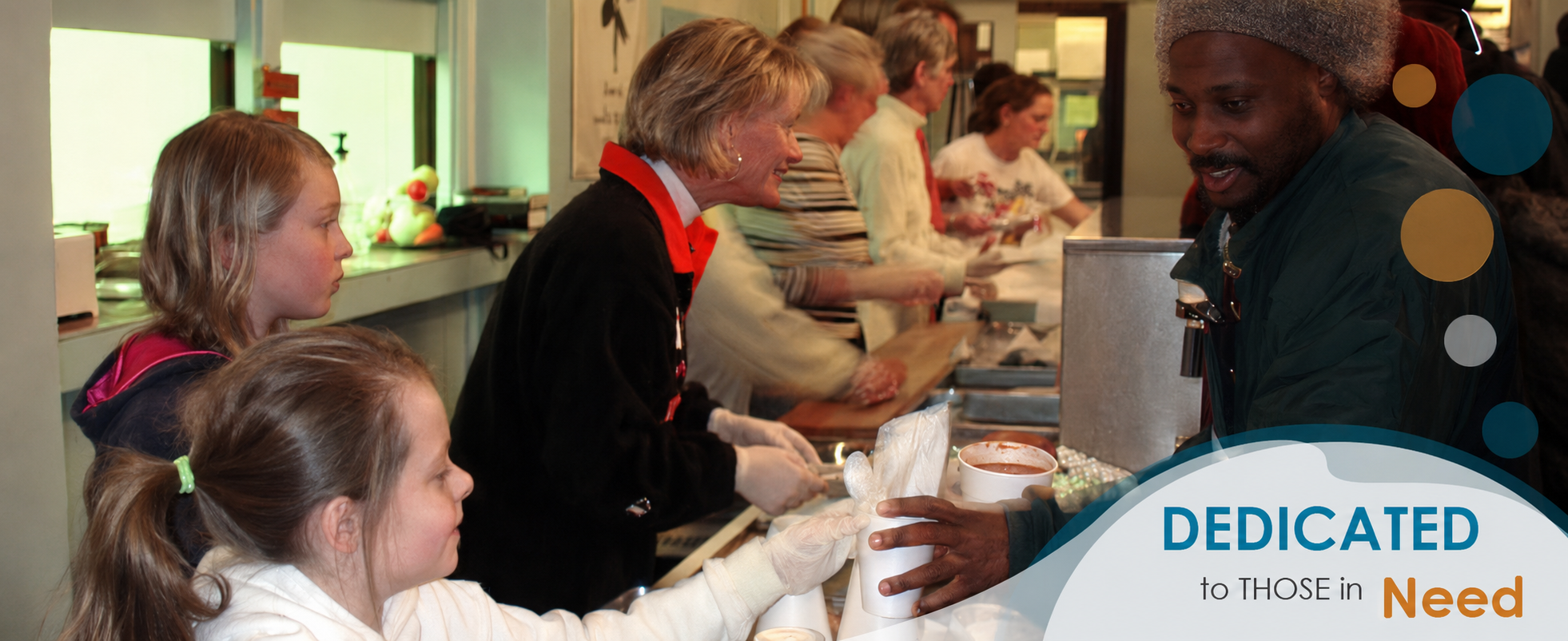 Children and adults preparing and serving food in a kitchen